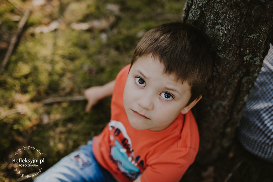 Chłopiec siedzący przy drzewie
