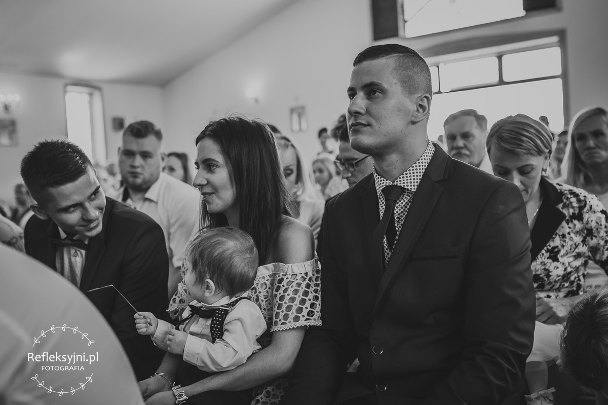 Mama trzyma dziecko na Chrzcie