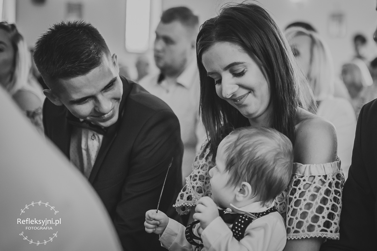 Mama trzyma dziecko na Chrzcie