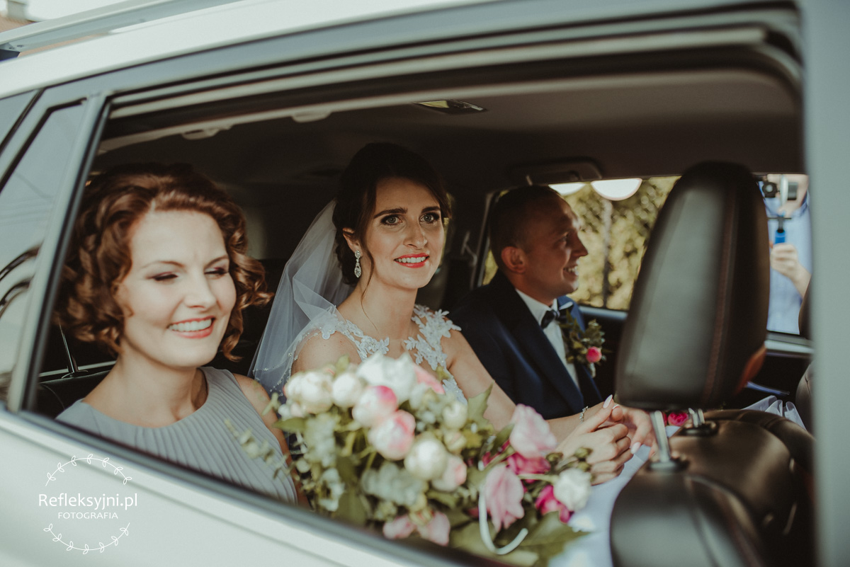 Panstwo Młodzi w samochodzie ślubnym
