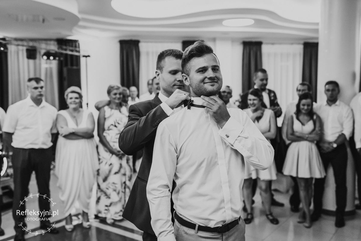 Zdjęcie przestawia gości na weselu bawiących się podczas oczepin ślubnych